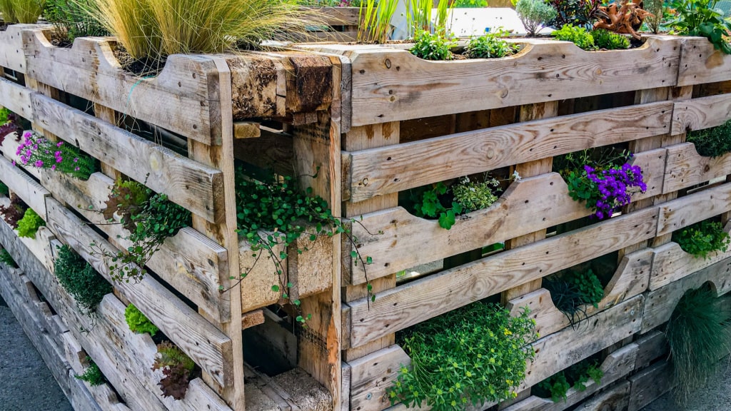 Übereinandergestapelt und celver arrangiert ergeben Holzpaletten einen stylischen Sichtschutz im Garten - der bestenfalls auch noch nachhaltig ist.