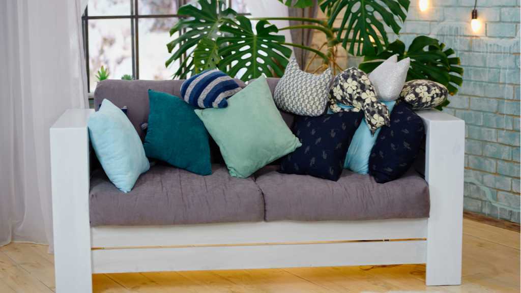 Große Monstera neben einem Sofa im Wohnzimmer