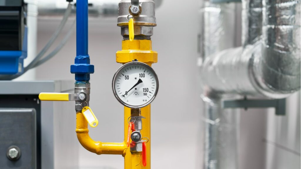 Manometer an einer gelben Rohrleitung