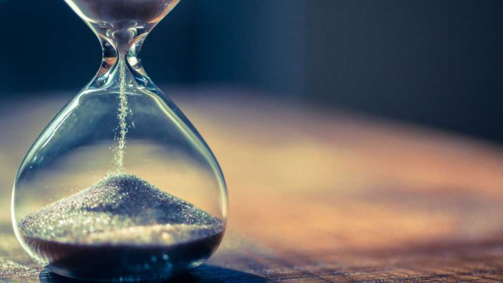 Nahaufnahme einer Sanduhr auf einem Holztisch