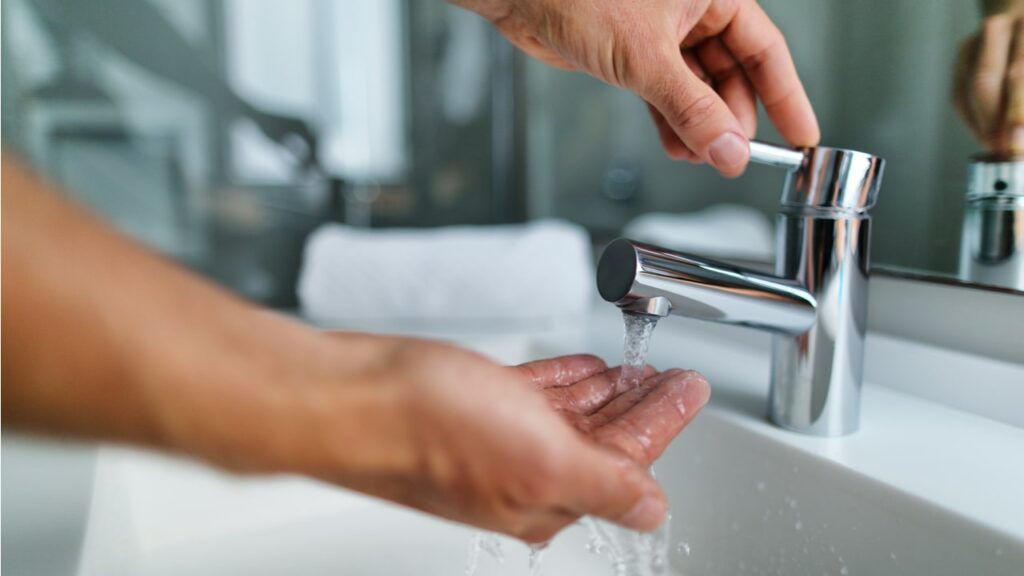 Hände unter einem laufenden Wasserhahn
