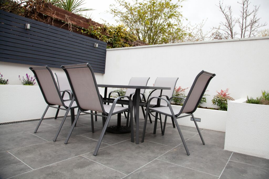 Graue Gartenmöbel mit Tisch und sechs Stühlen auf einer Terrasse