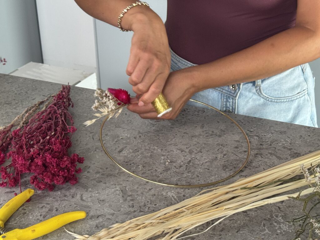 Frau bindet Trockenblumenkranz