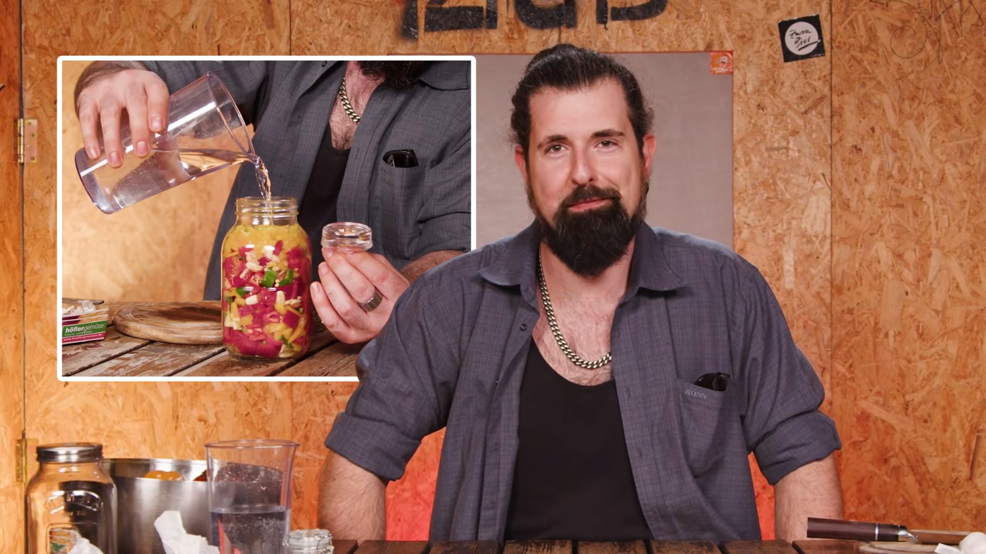 Mann sitz an einem Tisch, dahinter ein Bild von einem Fermentationsglas