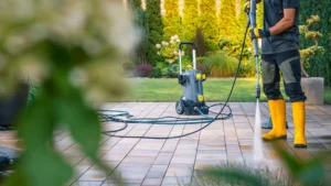 Mann reinigt eine Terrasse mit einem Hochdruckreiniger
