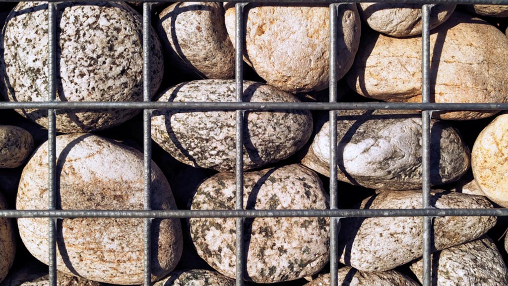 Ein Metallgitter in dem Metallgitter befinden sich einen Haufen an Steinen