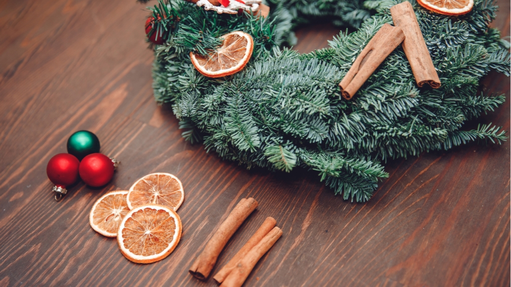 Ein Türkranz mit Zimtstangen, Orangescheiben oder Kugeln sind eine ideale Weihnachtsdeko für draußen.
