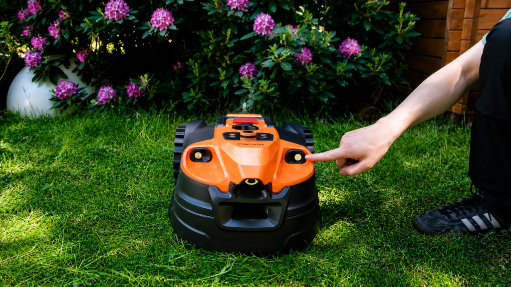 Person zeigt auf einen Frontsensor des orangefarbenen OcuMow 18